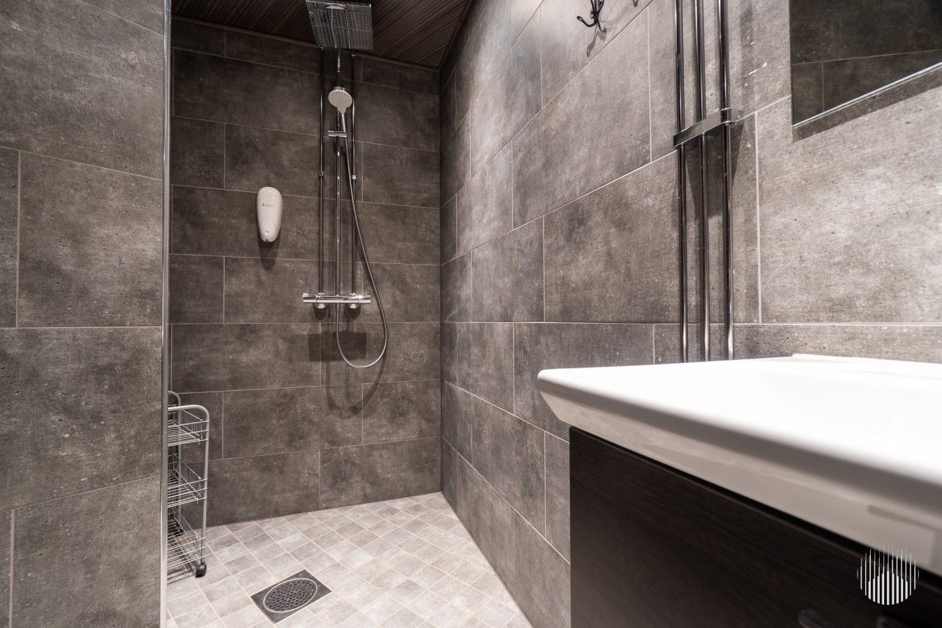 A modern bathroom with a shower, a toilet, and a sink.
