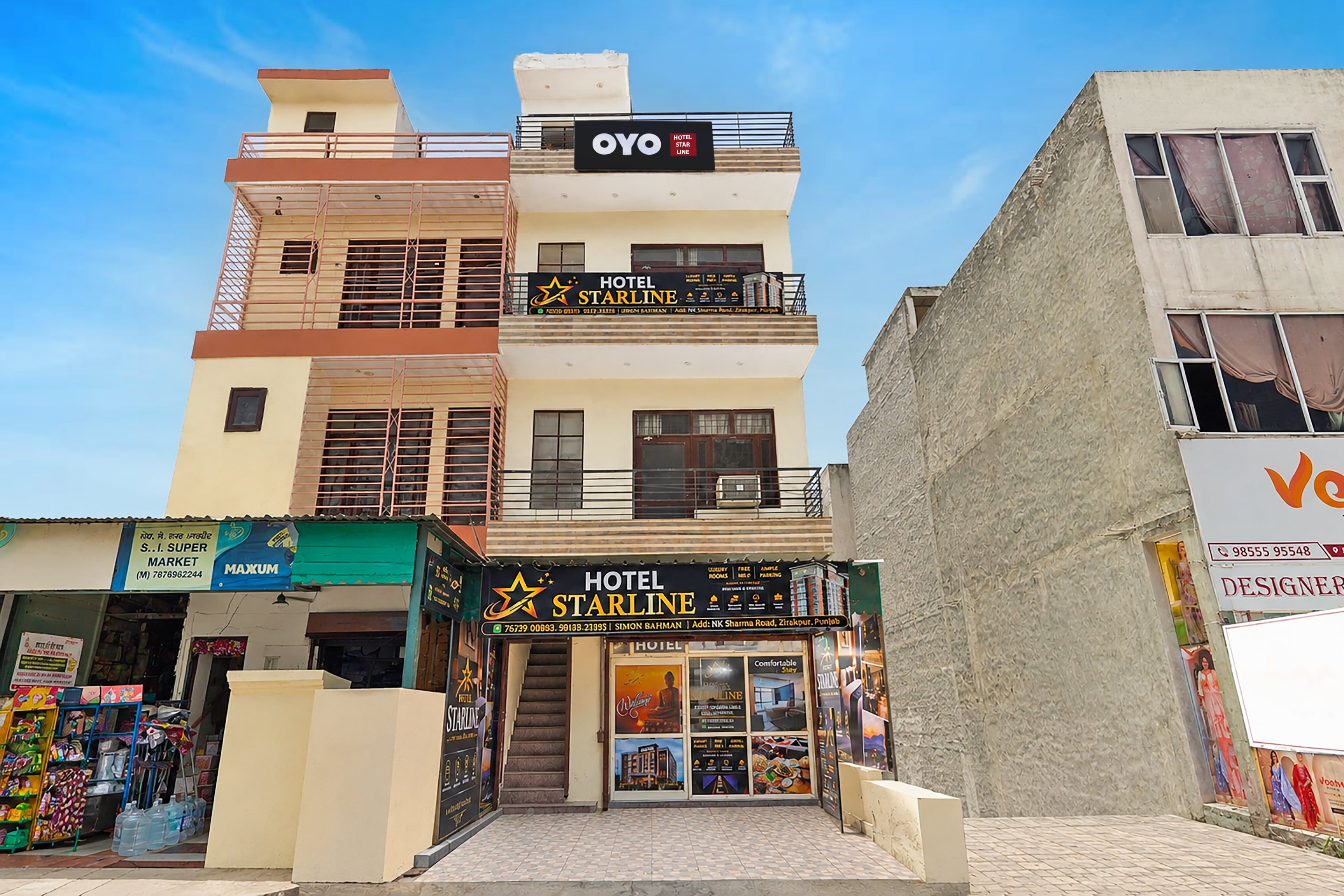 Un hotel de varios pisos con un letrero llamativo que dice 'OYO HOTEL STARLINE' en el último piso.