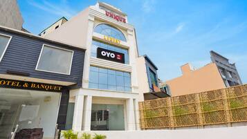 Un hotel con un cartel que indica 'OYO Hotel Unique' y 'Luxury' en la fachada.