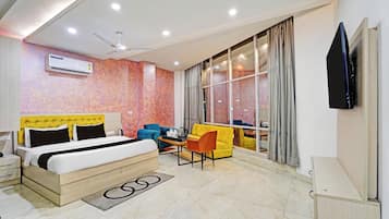 A hotel room with a bed, a desk, a chair, and a television.