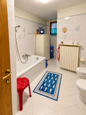 Un bagno con vasca, WC e doccia.