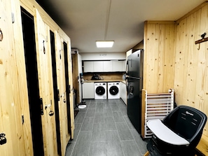 Une cuisine de taille réduite équipée d’un lave-linge, d’un réfrigérateur et d’une chaise.