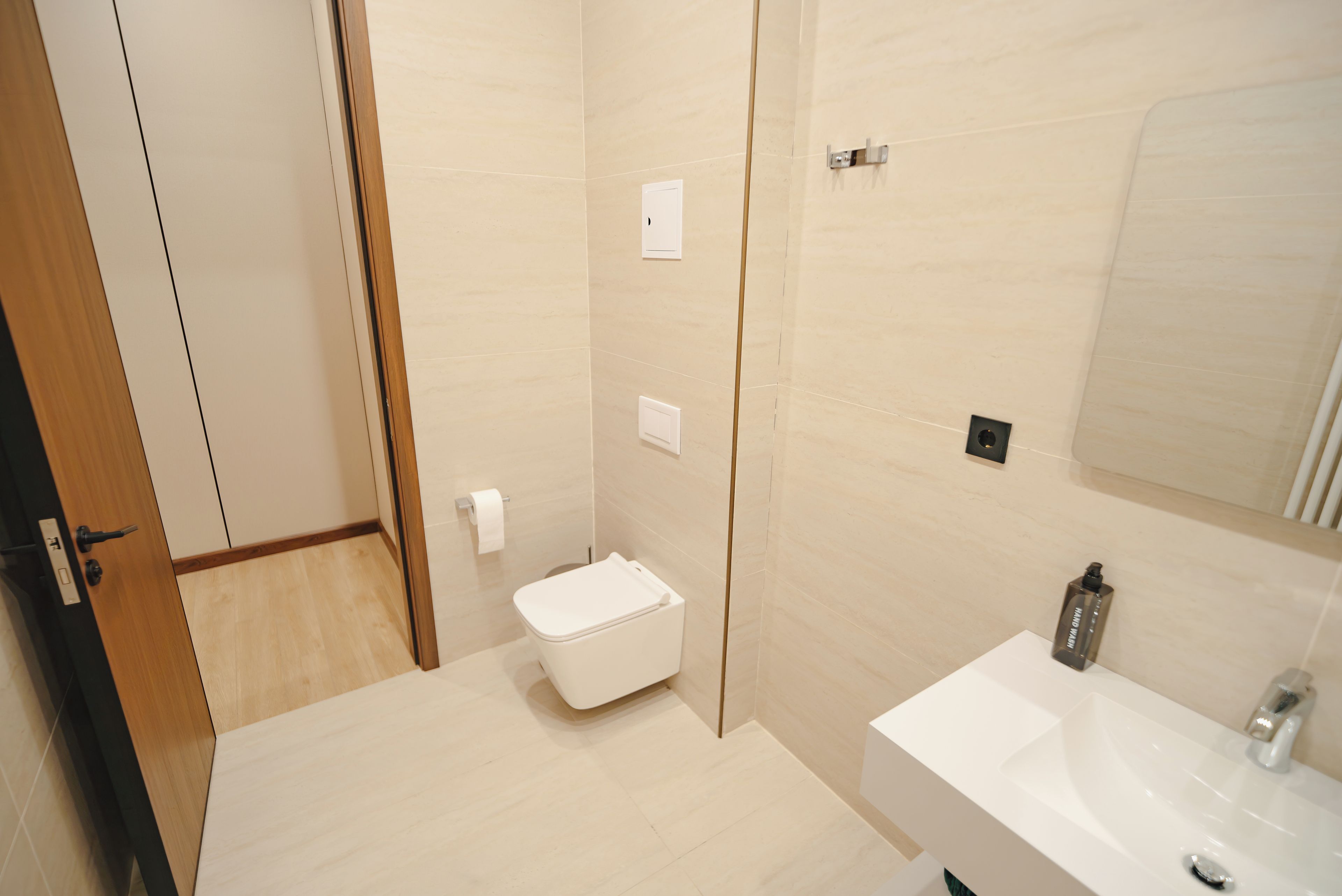 Un baño moderno con inodoro, lavabo y espejo.