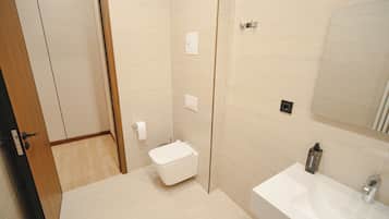 Un baño moderno con inodoro, lavabo y espejo.