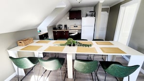 Una cucina moderna con pensili scuri, un frigorifero bianco e un forno a microonde sul piano di lavoro.