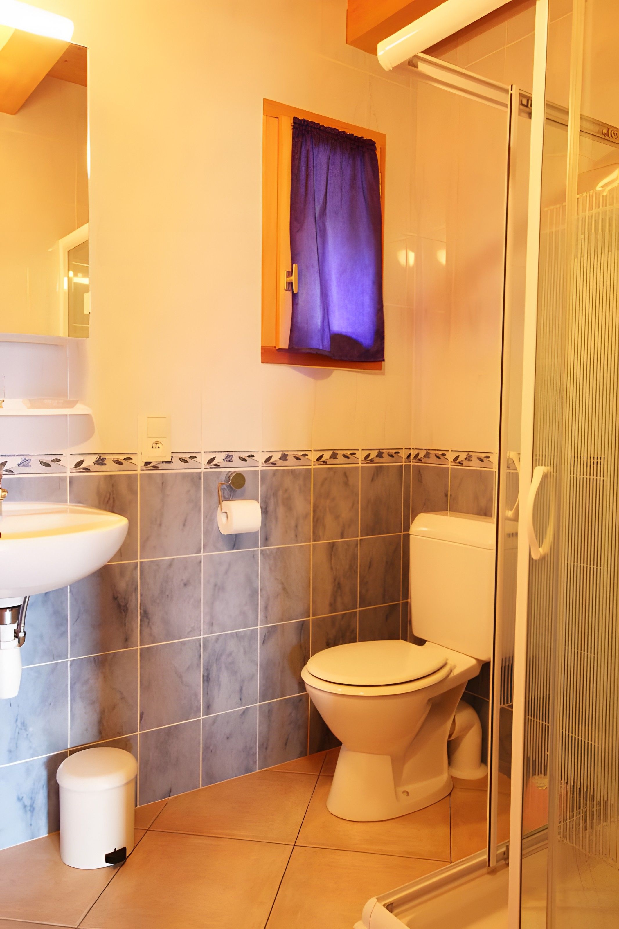 A bathroom with a toilet, sink, and shower area.