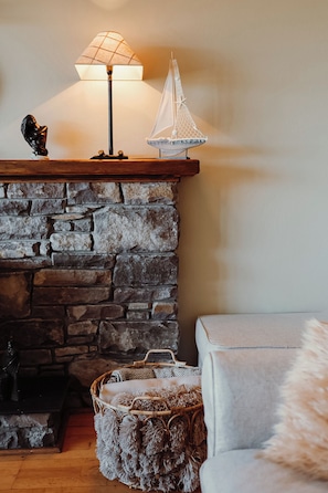 Una chimenea de piedra con una lámpara y una decoración de velero.