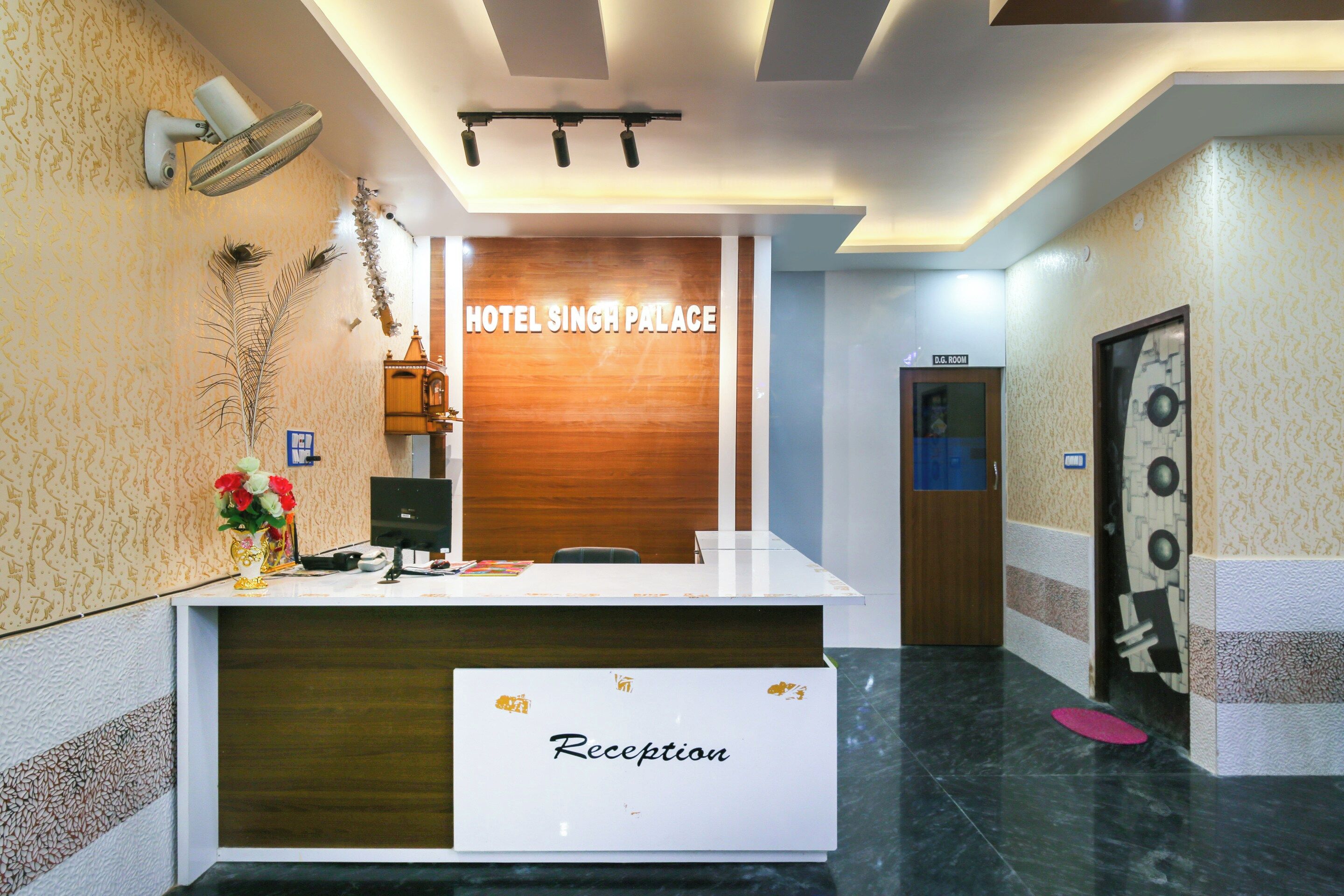 A reception desk with a sign reading 'HOTEL SINGH PALACE' and a 'Reception' label.