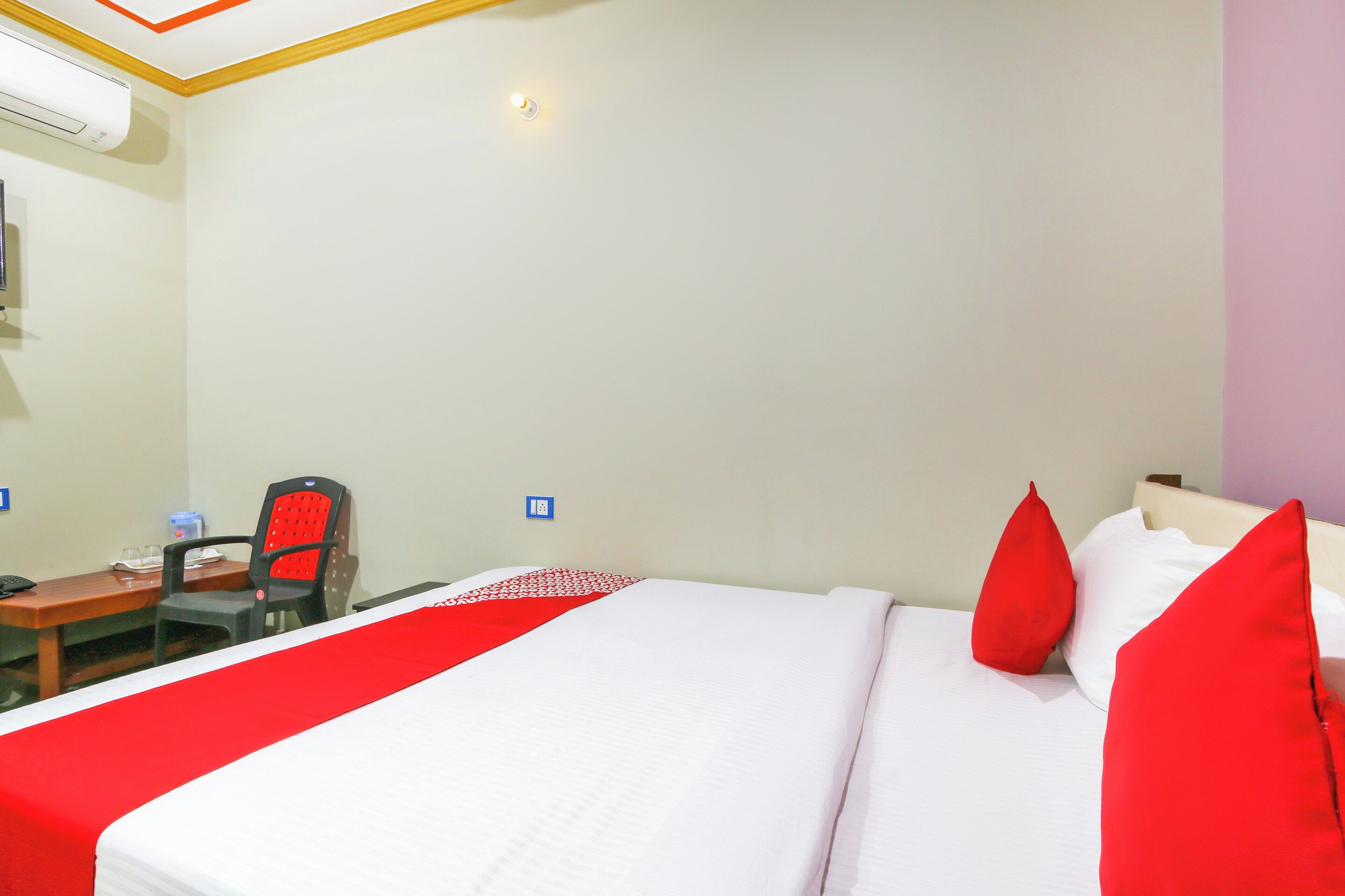 Una habitación de hotel con cama, escritorio, silla y una mesita.