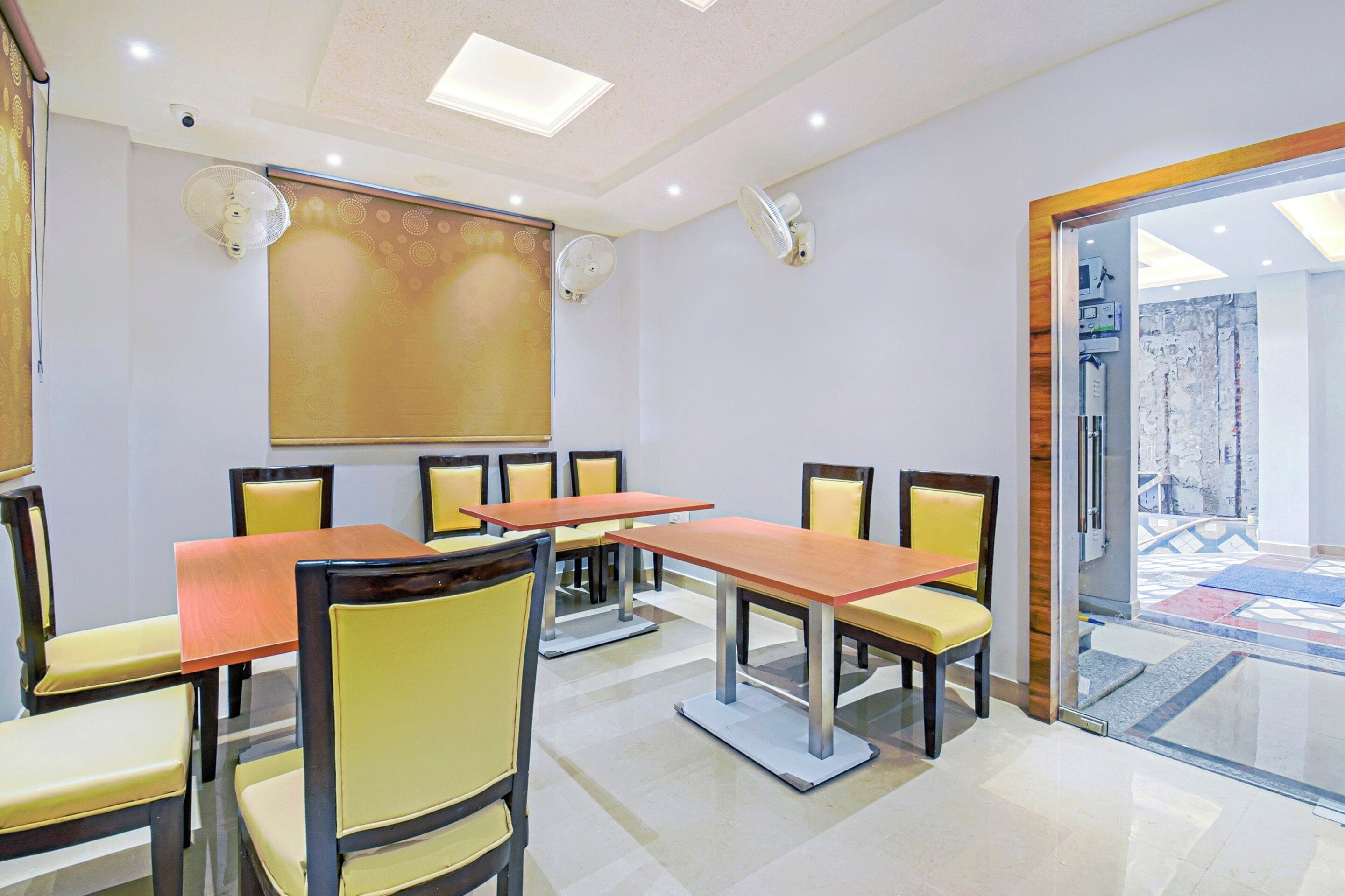 A conference room with a long table, chairs, a projector screen, and a glass door leading to an outdoor area.