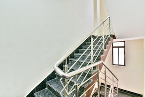 Un escalier avec des rampes en métal et une fenêtre dans le mur.