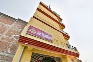 Un bâtiment sur lequel est apposée une enseigne bien visible indiquant « Hôtel Magadh Imperial », avec un numéro de téléphone à contacter.