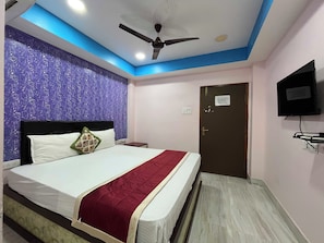 A hotel room with a bed, a ceiling fan, a television, and a door. - Hotel O Shree Karpagrram Dreams. (Port-Blair)