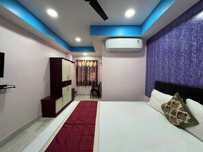 A bedroom with a bed, a wardrobe, an air conditioner, and a patterned wall. - Hotel O Shree Karpagrram Dreams. (Port-Blair)