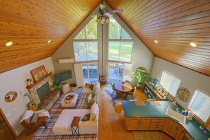 Un loft amplio con techos altos, ventanas grandes, chimenea, comedor y cocina.