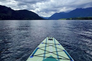 Un kayak en un lago tranquilo con montañas al fondo.