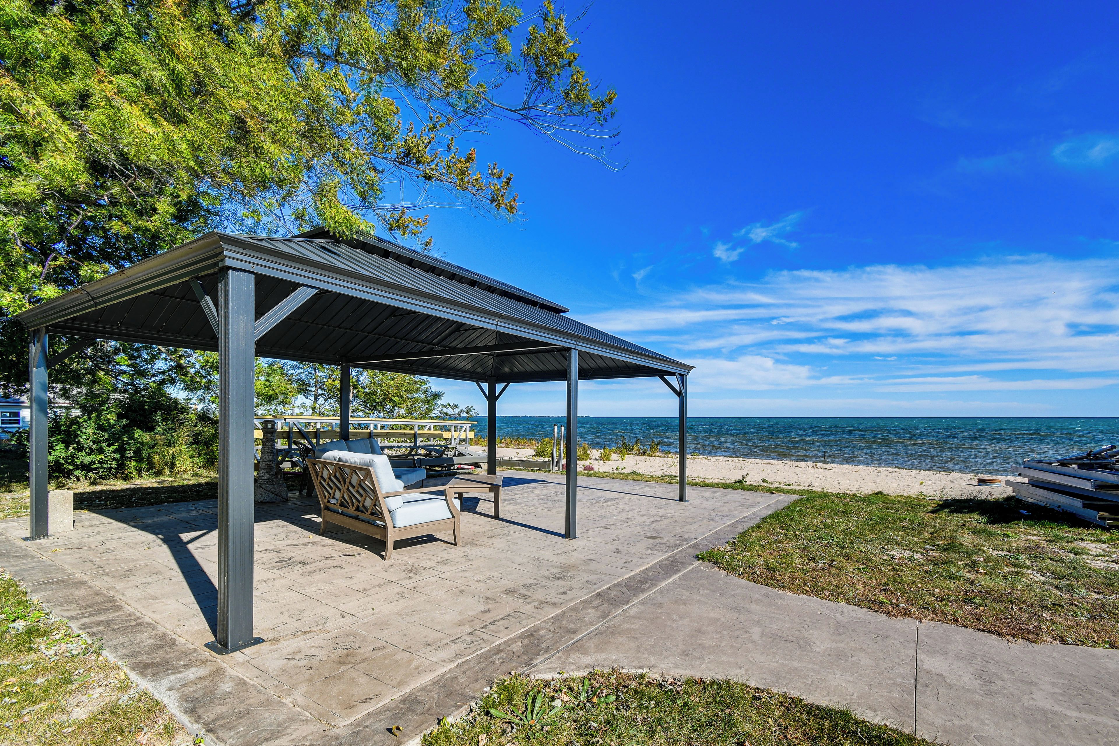 A covered outdoor seating area with a view of the sea.