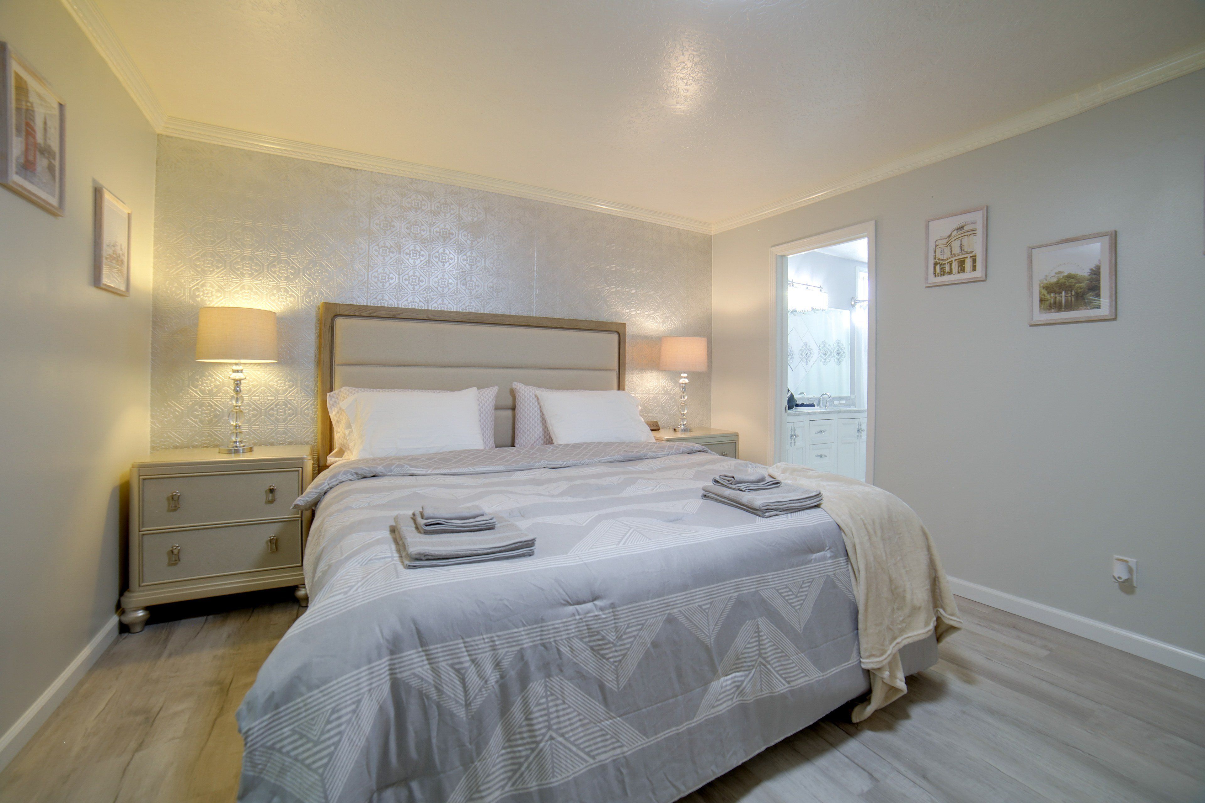 A bedroom with a large bed, two bedside tables, and a nightstand.