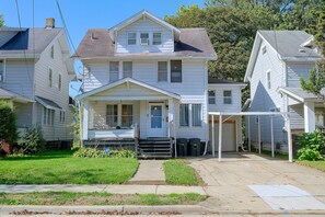 A two-story house with a front porch, a garage, and a covered driveway. - 1 Mi to Akron Zoo! Charming Home w/ Yard (Akron)