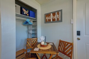 Uma sala de jantar com mesa de madeira, cadeiras e prateleira fixada na parede com caixas organizadoras.