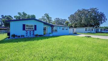 A single-story mobile home with a blue exterior and a small front yard.