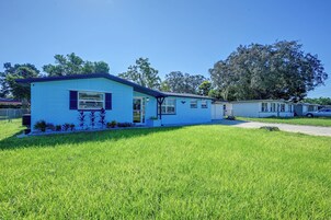 Casa móvel térrea com fachada azul e pequeno jardim frontal.