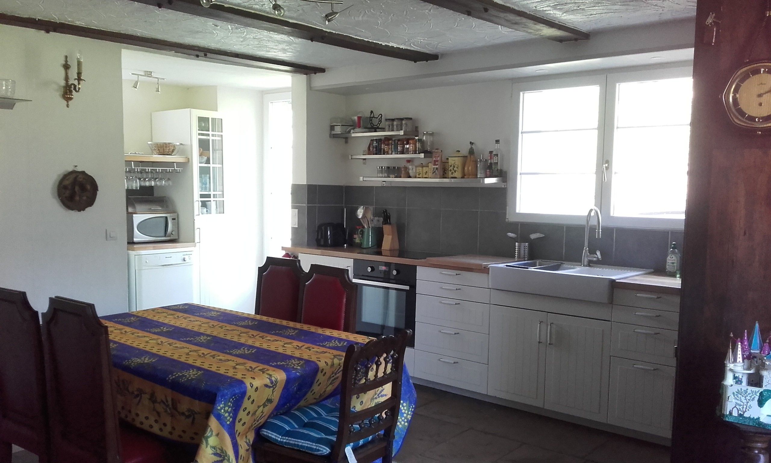 Een keuken met een eettafel, stoelen en een raam.