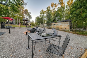 An outdoor seating area with tables and chairs, a barbecue grill, and a red umbrella. - 1 Mi to Kentucky Lake! 'special Place' Tiny Home (Springville)