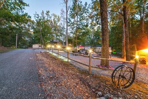 A gravel path leading to a building with outdoor seating, surrounded by trees.