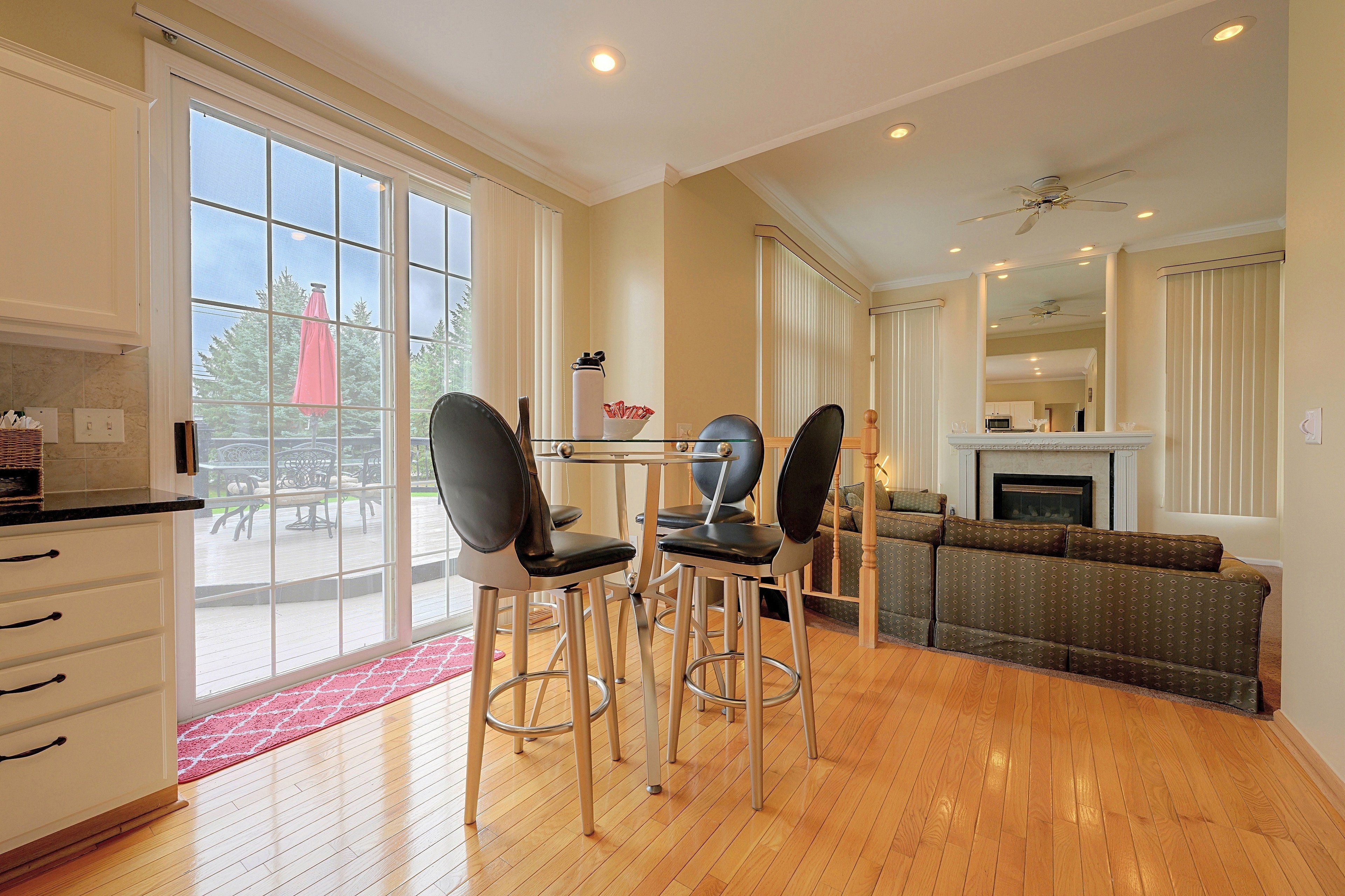 A spacious living area with a dining table, chairs, a sofa, and a fireplace.