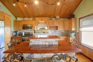 A kitchen with wooden cabinets, a stone island, and a built-in oven.