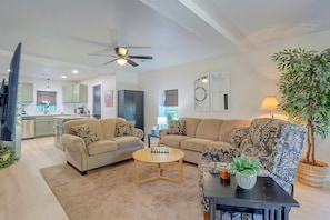 A living room with a sofa, armchairs, a coffee table, and a television. - Guthrie Home in the Heart of Historic Downtown! (Guthrie)