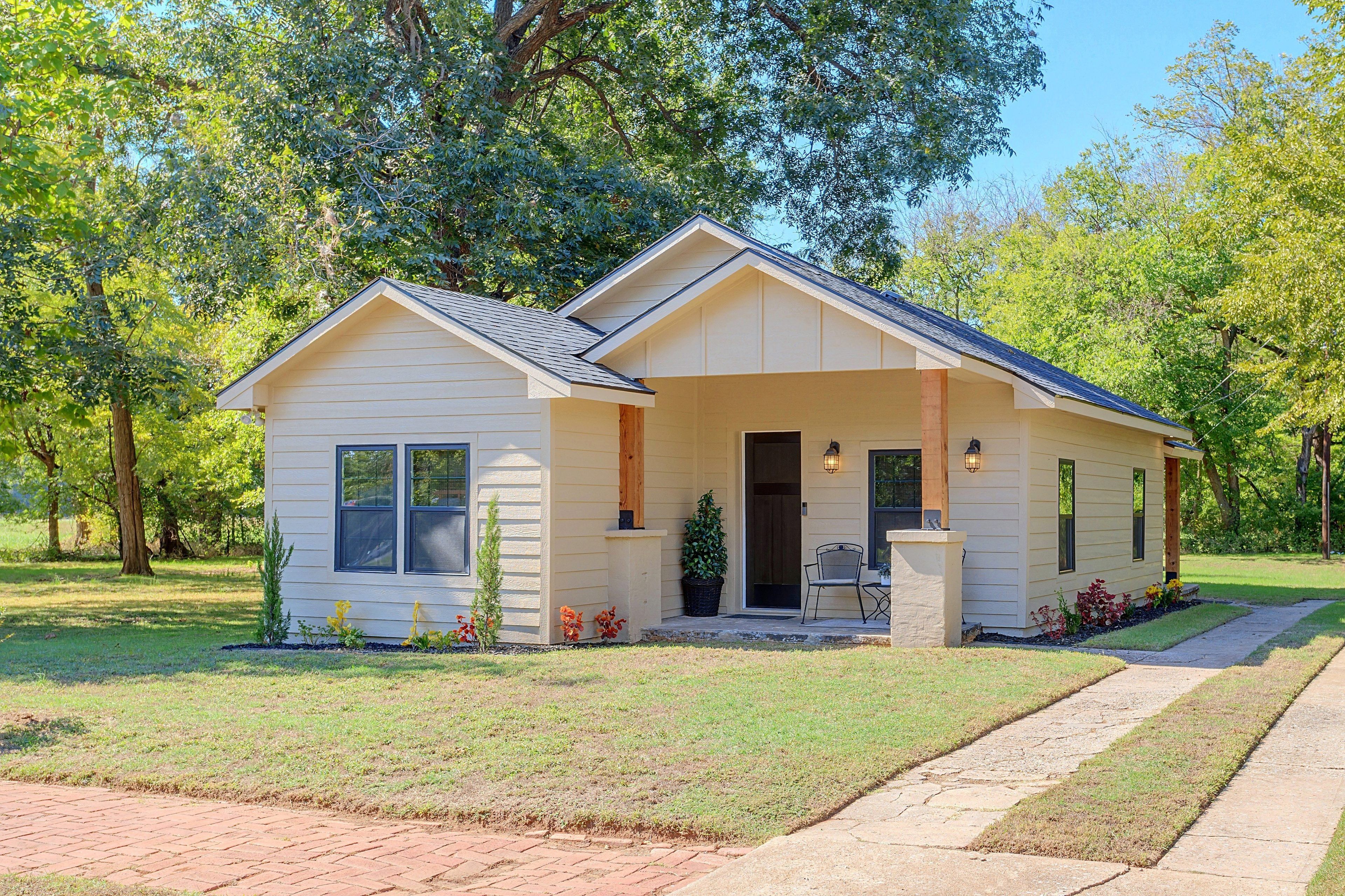 A single-story house with a gabled roof, a front porch, and a small front yard.