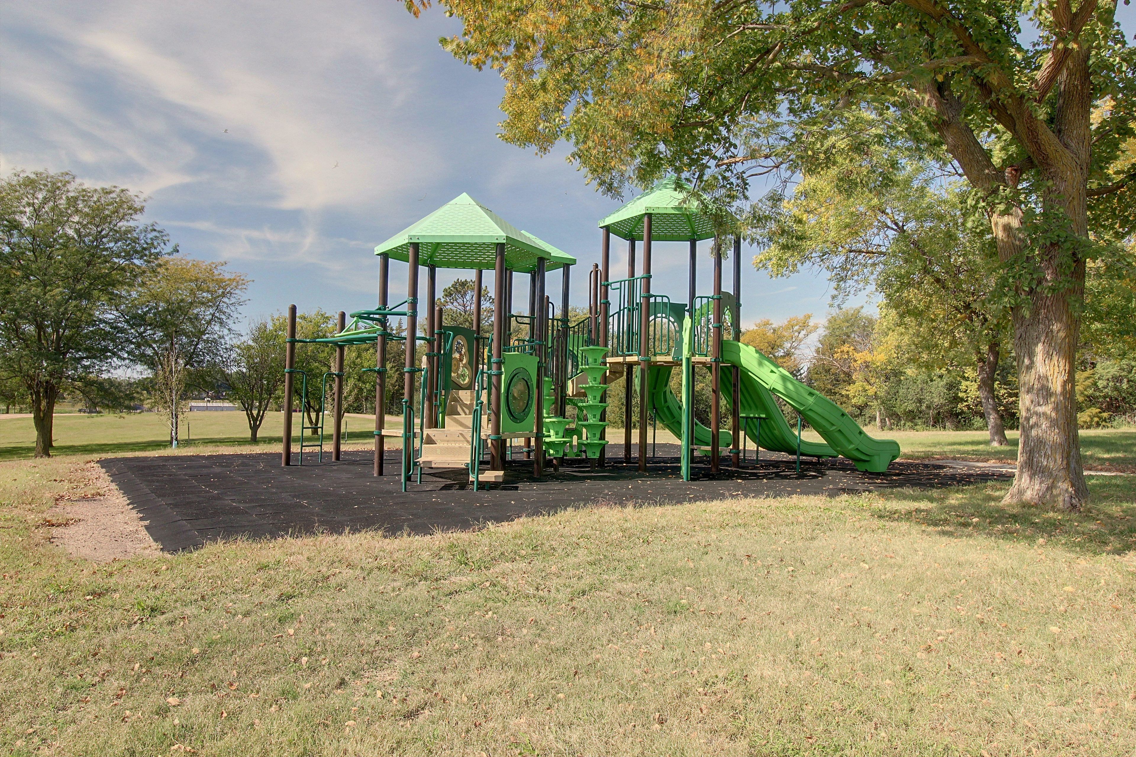 A playground with a slide, climbing structures, and a covered play area.