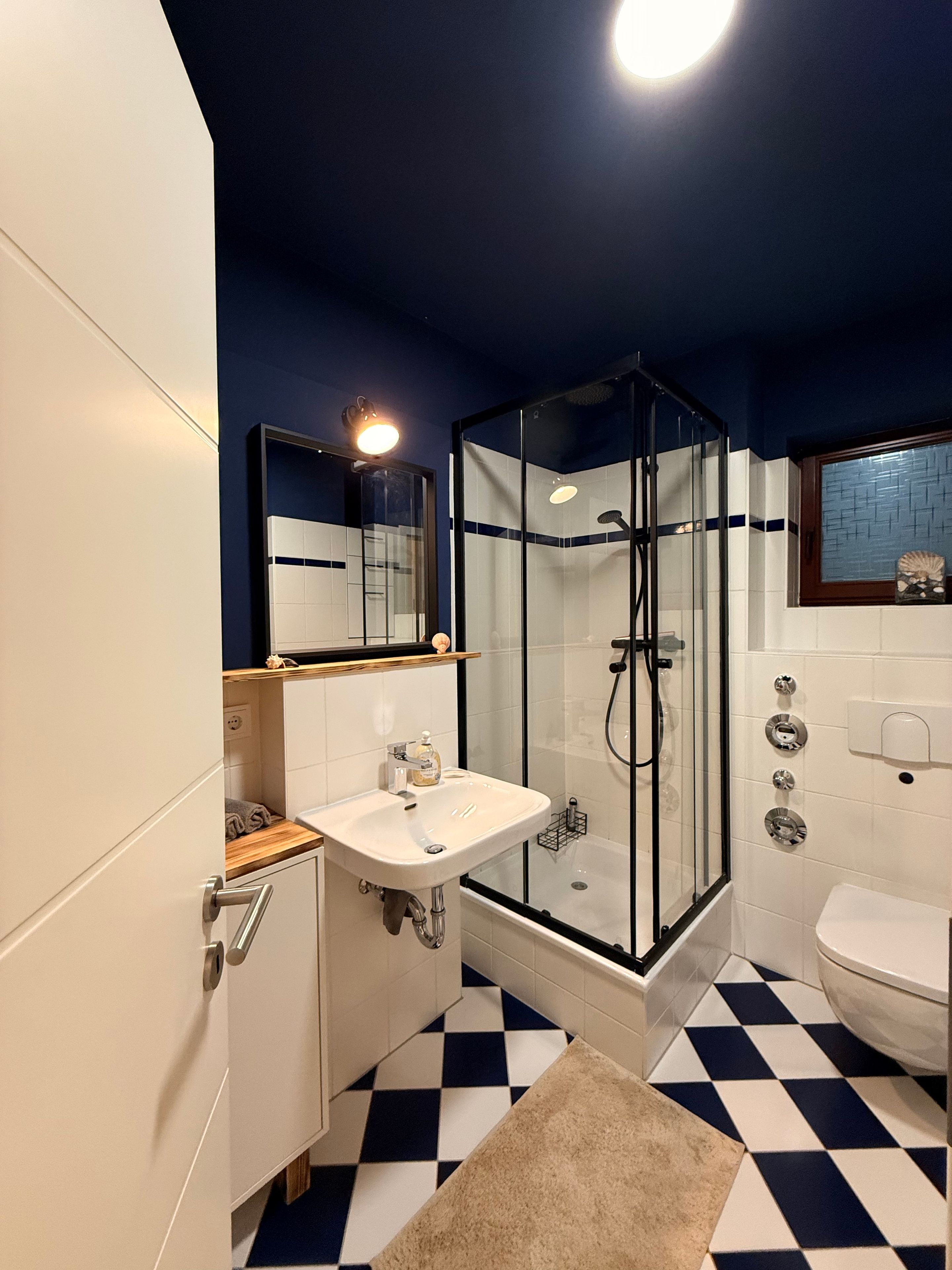 Ein Badezimmer mit einer Duschkabine, einem weißen Waschbecken und einer weißen Toilette.