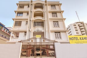 Un edificio de varios pisos con un letrero que dice 'RAVI MANSION' y 'HOTEL KAMINI', indicando que es un hotel.