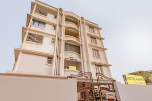 Un edificio de varios pisos con una entrada principal destacada y un letrero que indica que es un hotel.