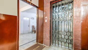 A hotel entrance with a metal gate, a welcome mat, and a door with a sign indicating room number 103.