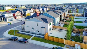 Un barrio residencial con casas, una calle y un automóvil.