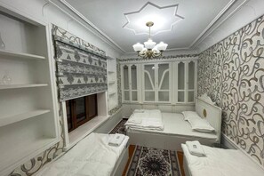A room with a bed, a window, a chandelier, and patterned walls. - Guesthouse Anora 4 (Samarkand)