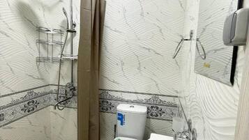 Un baño con ducha, inodoro y lavamanos.
