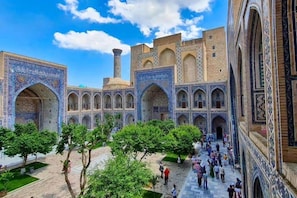A courtyard with a traditional building featuring arched walkways and intricate tile work. - Guesthouse Anora 4 (Samarkand)