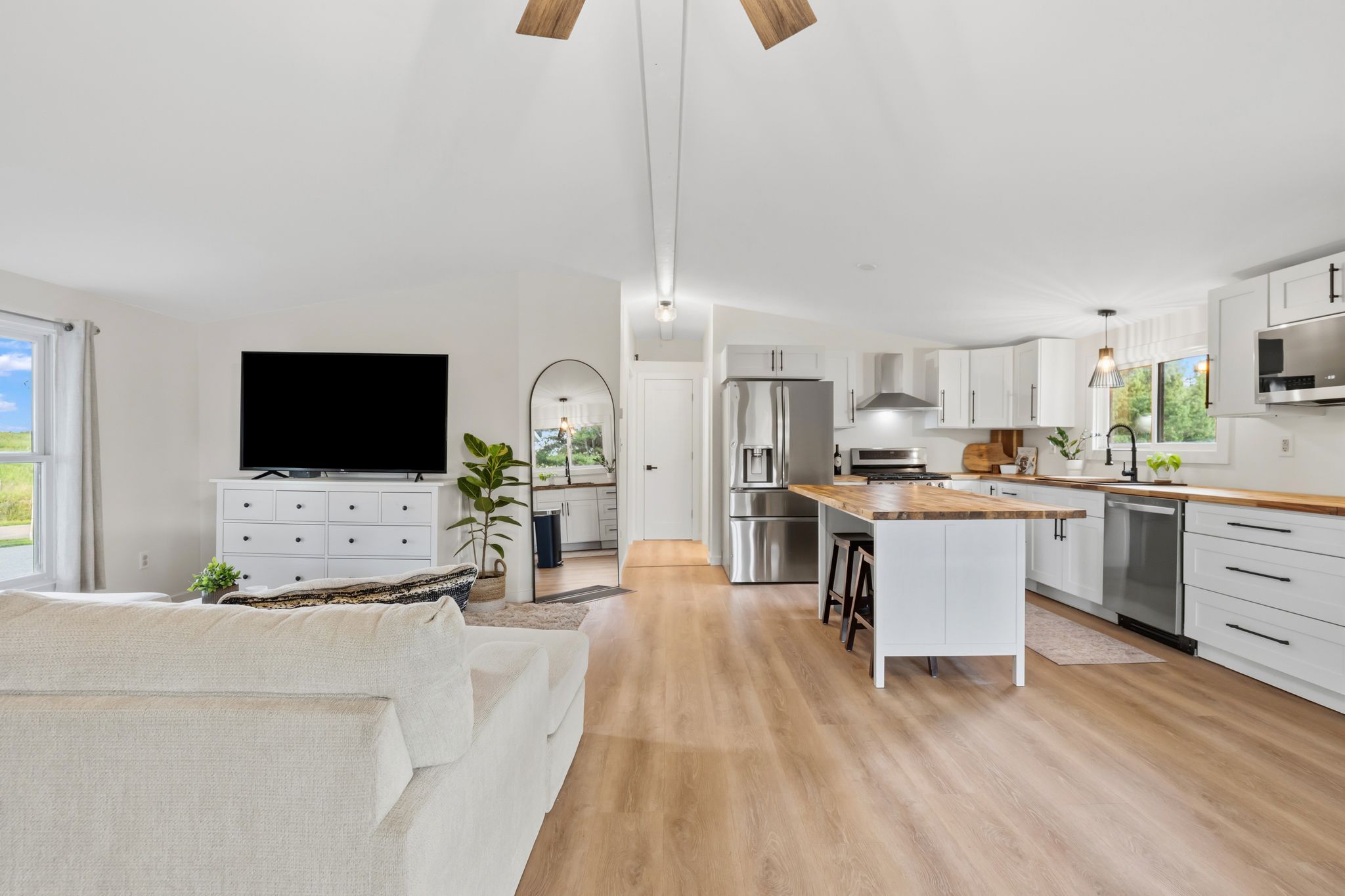 Een moderne keuken met een centraal eiland, roestvrijstalen apparatuur en witte kasten.