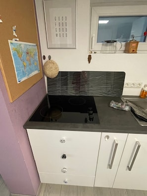 A kitchen with a stove, a wall-mounted map, and a framed motivational quote. - Apartment 'Bärenhöhle Vacation Home' with Shared Terrace, Shared Garden and Wi-Fi (Schlangenbad)