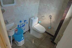 Une petite salle de bain avec des toilettes, un lavabo et une douche.