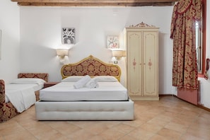 A hotel room with a bed, a wardrobe, two bedside lamps, and a small table. - Ca' Residenza Rialto (Venice)