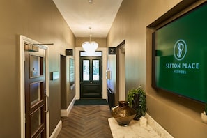 A hotel hallway with a reception desk, a chandelier, and a sign for Sefton Place Arundel. - *NEW* Large Luxury Garden Terrace Suite in South Downs (Warningcamp)