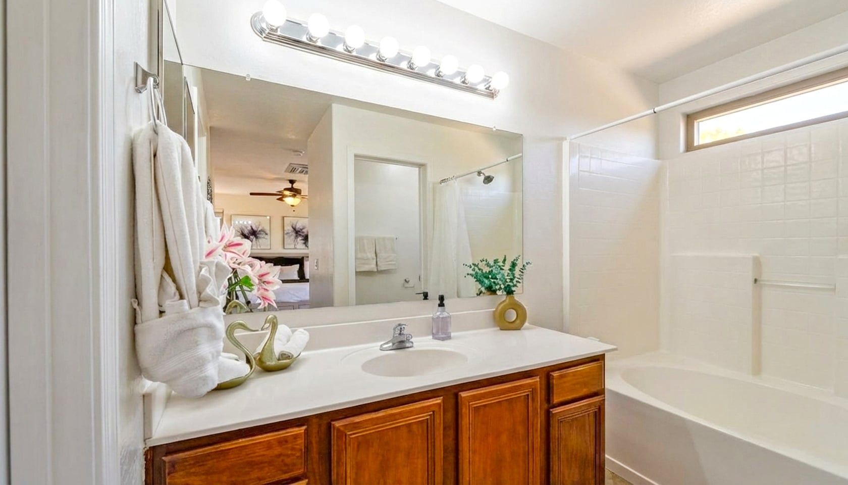 A bathroom with a vanity, mirror, and a shower.