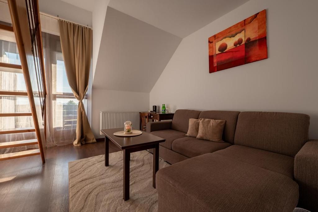 Una sala de estar moderna con un sofá marrón, una mesa de madera y un cuadro en la pared.