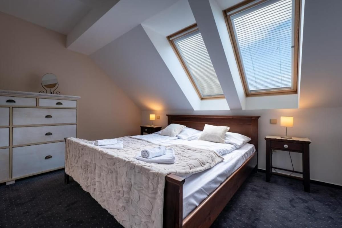 Une chambre à coucher avec un lit, une commode et deux lampes de chevet.